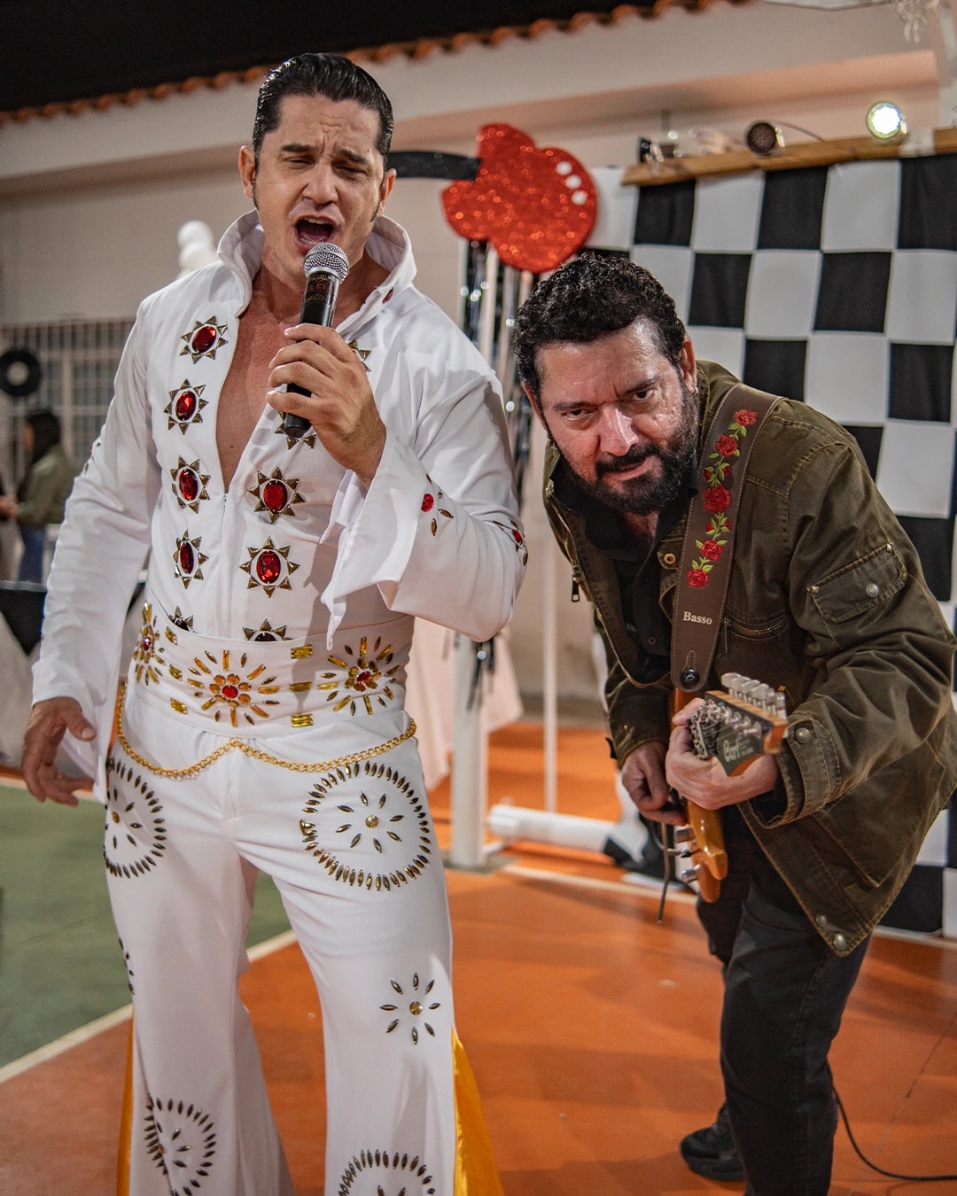 Cantor vestido de Elvis se apresentando com um guitarrista na Festa das Famílias