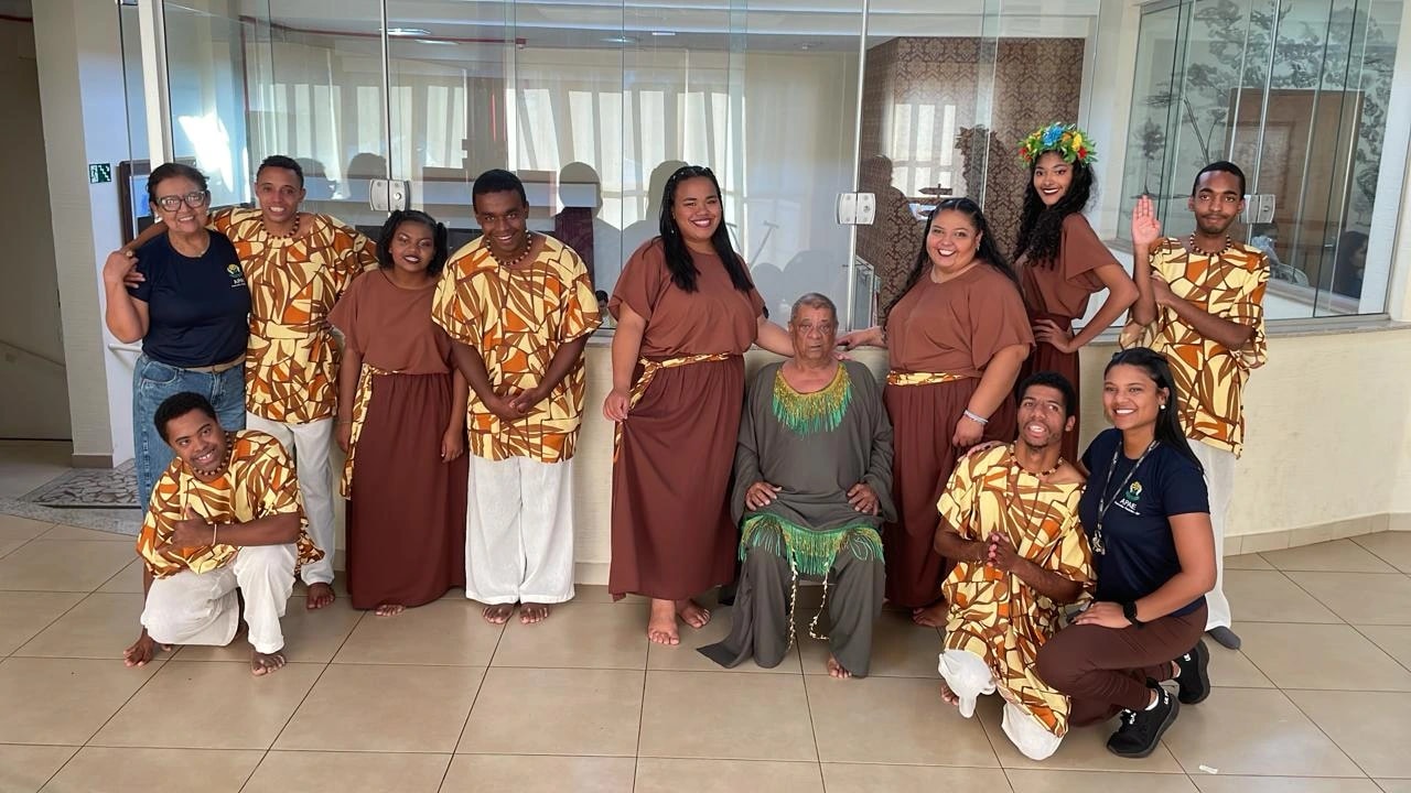 Grupo de dança da APAE com figurinos estampados em tons de marrom e laranja, posando junto