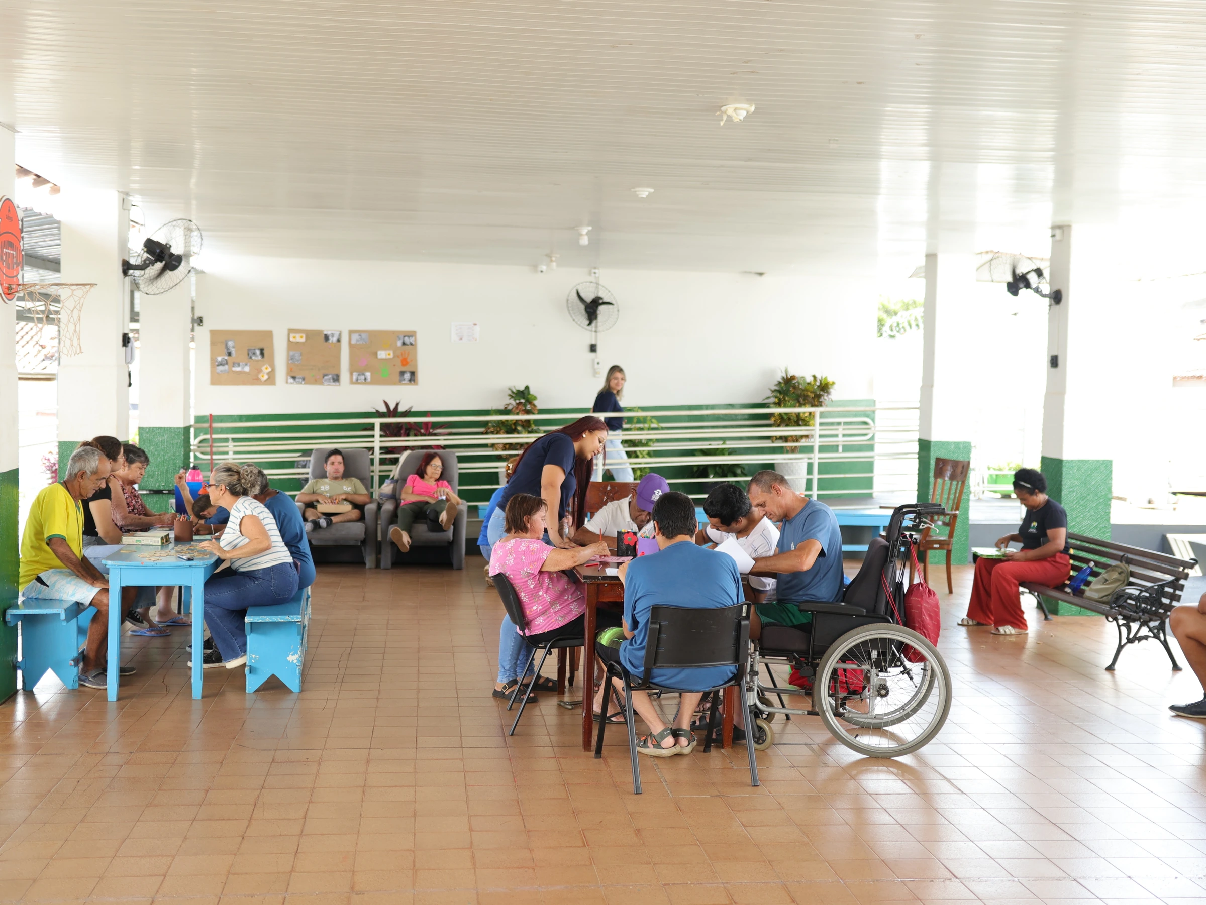 Salão do Centro-Dia da APAE com atendidos e equipe em atividades de convivência